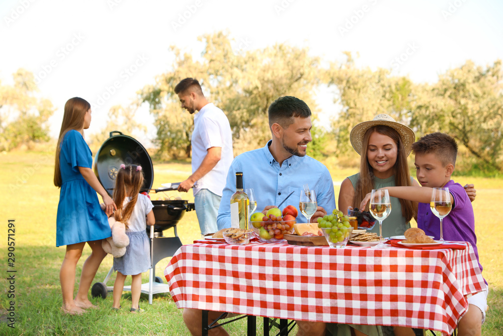 Happy families with little children having picnic in park Happy families with little children having picnic in park