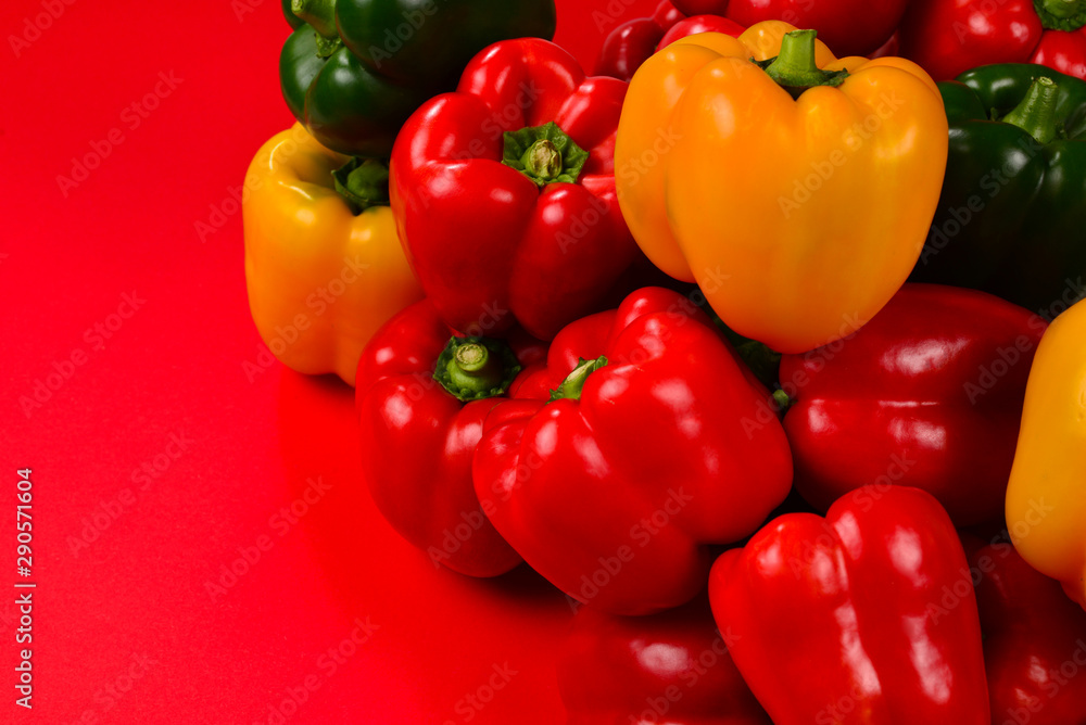 Fresh red, yelow, green bell pepper on a red background. Fresh red, yelow, green bell pepper on a red background.