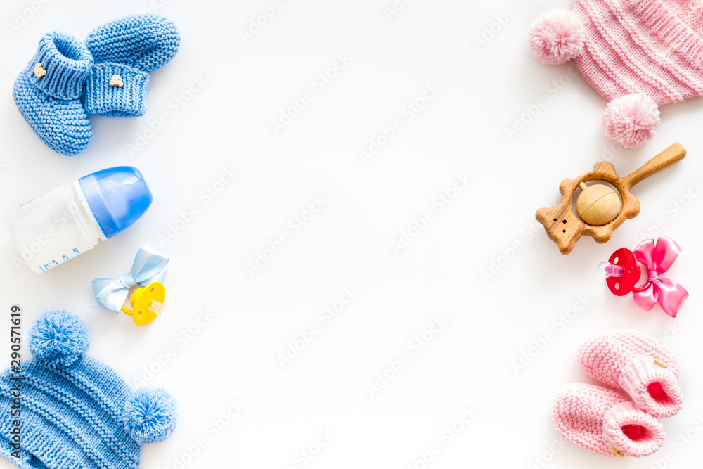 Cute baby clothes for boy and girl, rattle, bottle and dummy on white background top view copyspace - obrazy, fototapety, plakaty 