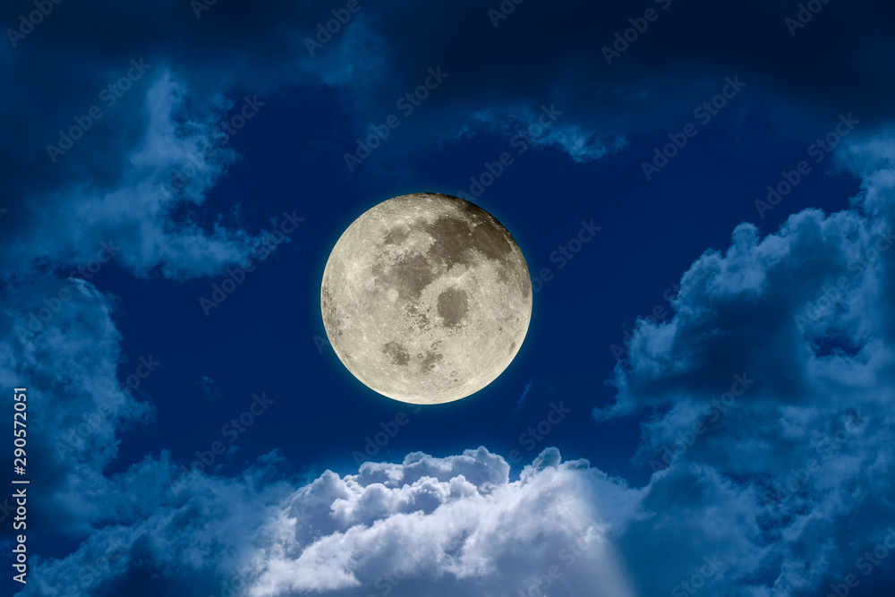 Fototapeta Big bright and shining full moon against a dark night sky dramatic seen through a hole in the clouds. Elements of this image furnished by NASA