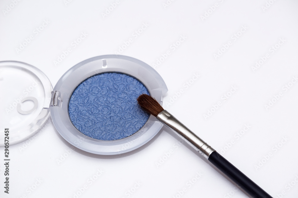 Blue eye shadows and eye brush isolated on white background. Concept of makeup and beauty. Blue eye shadows and eye brush isolated on white background. Concept of makeup and beauty.