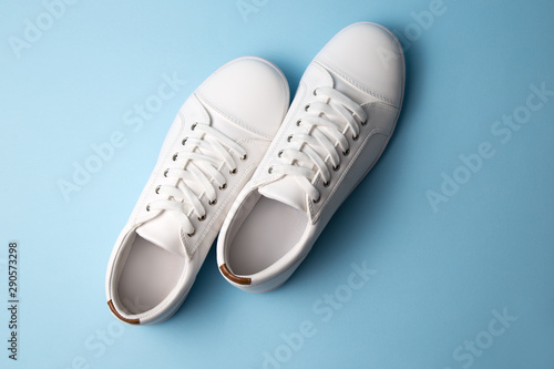 Pair of white sneakers on blue background. Fashion blog or magazine concept.