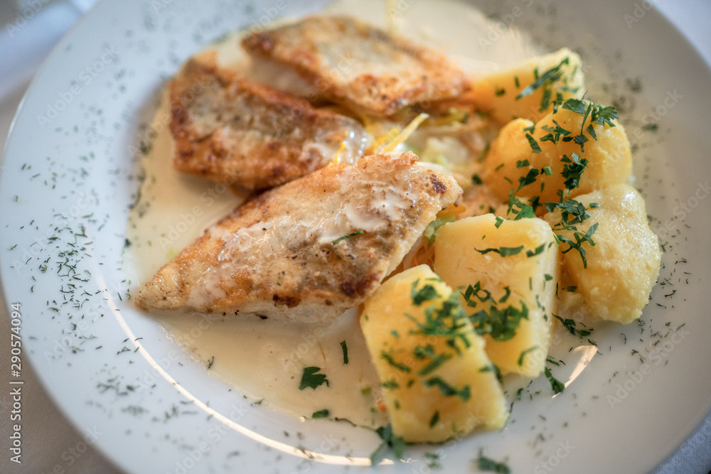 Cross fish with potatoes on plate