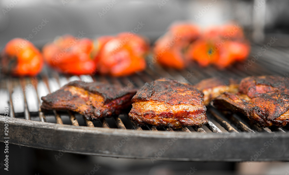 Close up of grilled meat with red pepper outdoor on grid