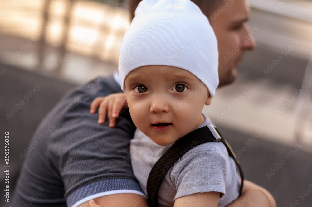 Father with one year old baby in his arms. Walk in an urban environment. The concept of urbanization and life in the city. The development of emotional intelligence. Early development. Father with one year old baby in his arms. Walk in an urban environment. The concept of urbanization and life in the city. The development of emotional intelligence. Early development.
