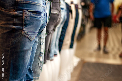 Many jeans are presented on mannequins in the store. Trade and shopping.