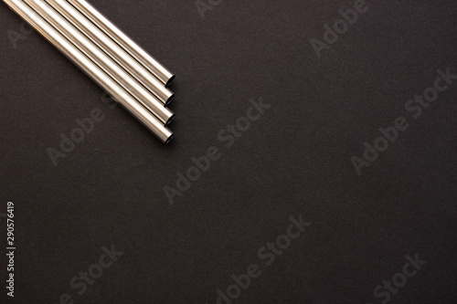 Metal straws on black background. Zero waste. Flat lay 