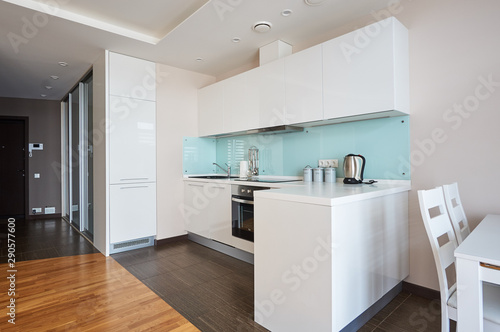 Wallpaper Mural minimalist kitchen with white facades and blue glass apron with white table and chairs Torontodigital.ca