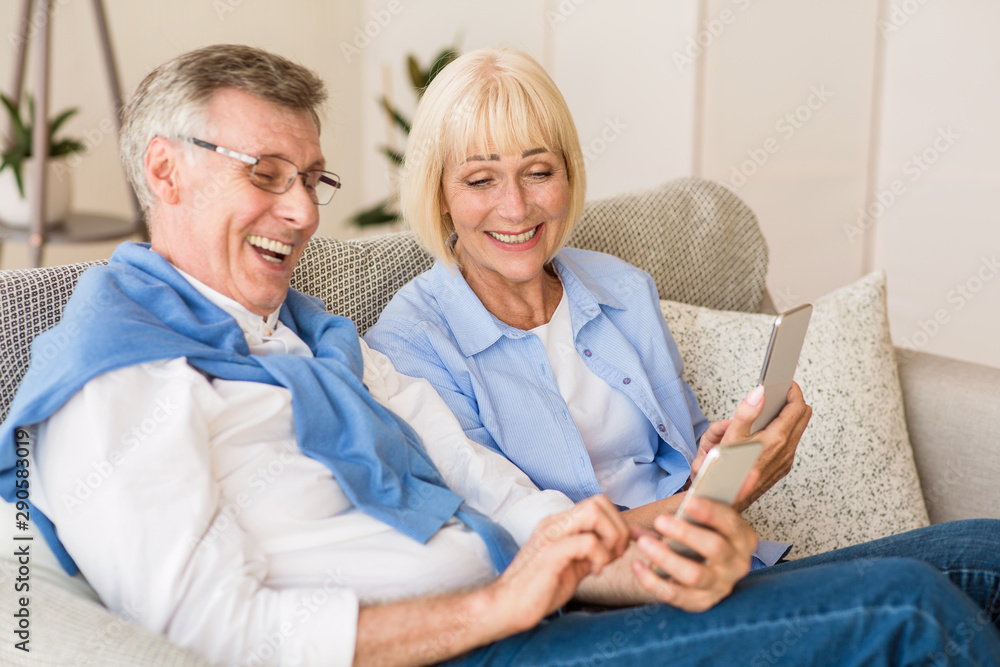 Happy mature couple watching funny videos on phone Happy mature couple watching funny videos on phone