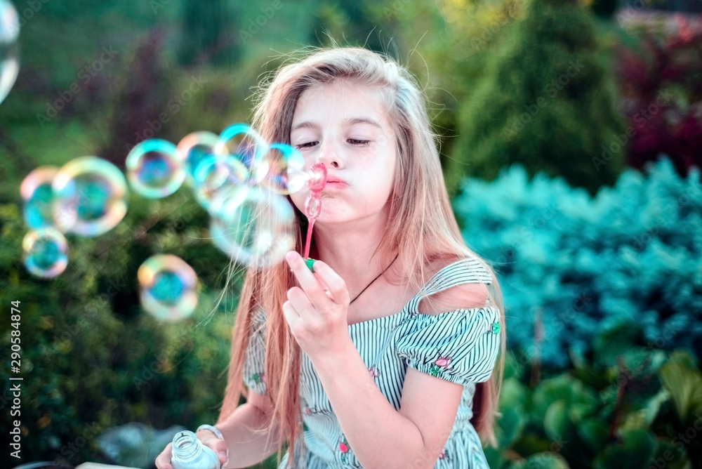 beautiful little girl child. Outdoors, blowing bubbles. Children's lifestyle