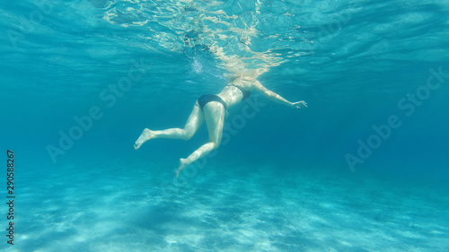 Underwater photo of woman swimming in tropical exotic bay with crystal clear sea © aerial-drone
