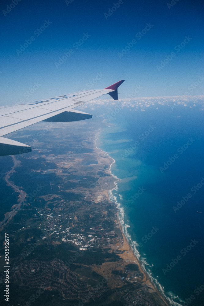 Obraz premium wing of an airplane flying above the clouds