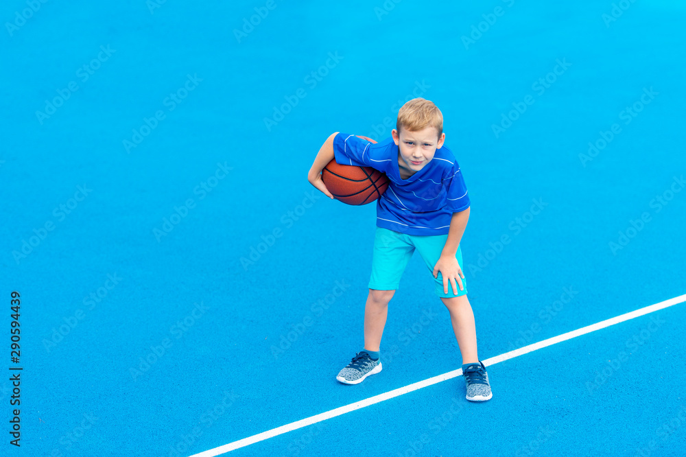 Obraz premium Adorable child playing the basketball in the basket field