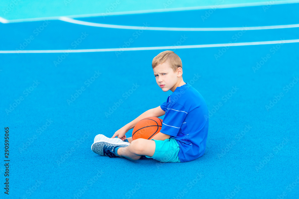Adorable child playing the basketball in the basket field Adorable child playing the basketball in the basket field