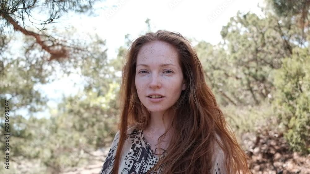 Portrait of red-haired woman in boho style outdoors. beautiful red-haired hippie girl. woman with green eyes and freckles relaxing at the beach in summer Portrait of red-haired woman in boho style outdoors. beautiful red-haired hippie girl. woman with green eyes and freckles relaxing at the beach in summer