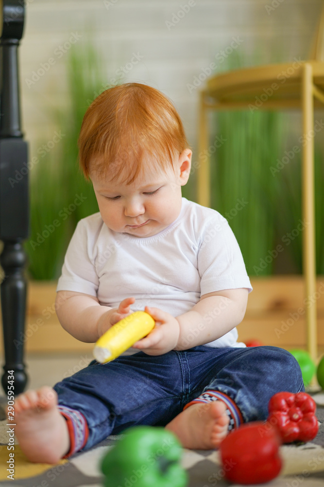 chubby child with red hair plays with vegetables chubby child with red hair plays with vegetables