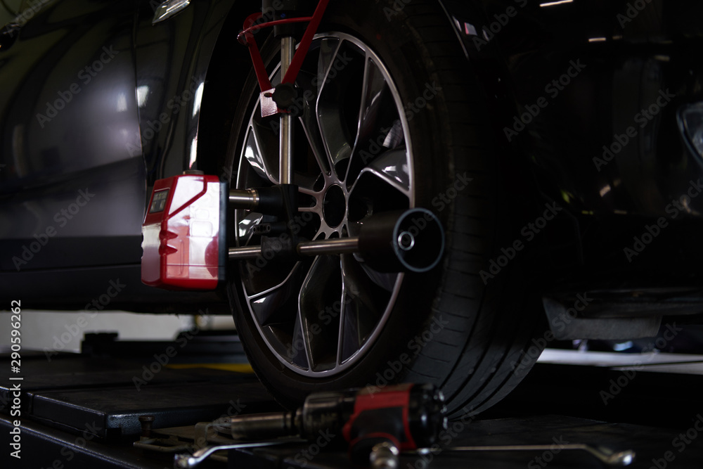 Fototapeta premium Closeup photoshoot of process or tyre balancing at dark auto service.