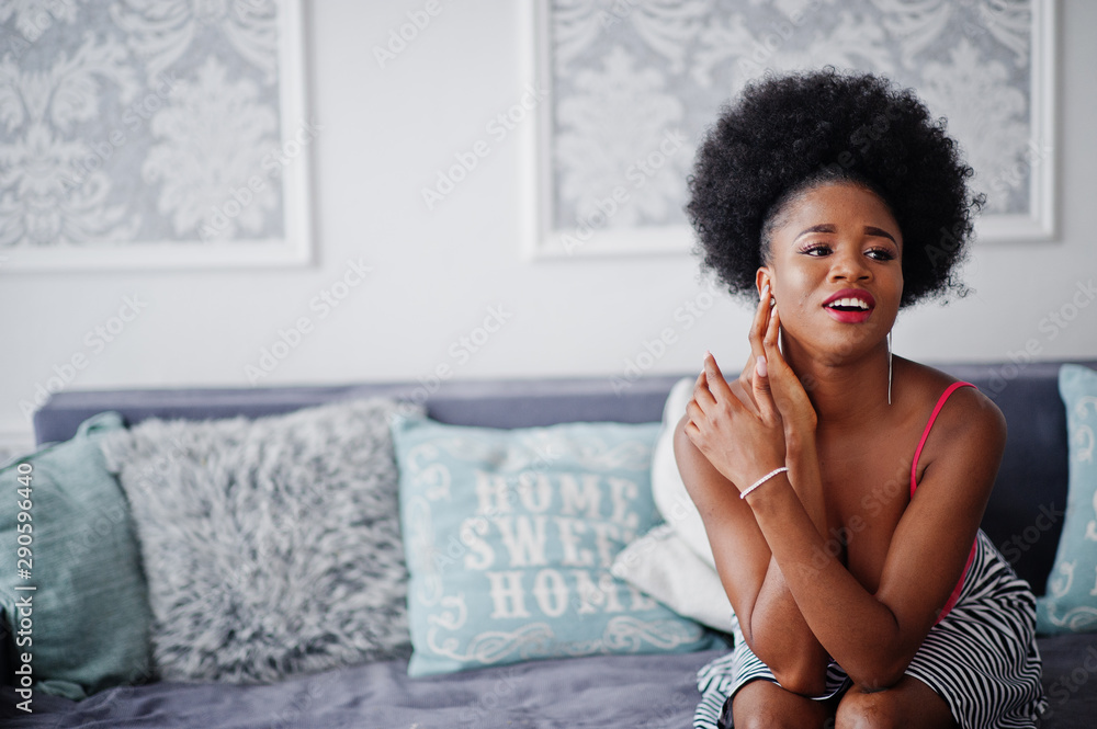 Attractive african american woman with afro hair wear on skirt pink top, posed at white room. Fashionable sexy black model. Attractive african american woman with afro hair wear on skirt pink top, posed at white room. Fashionable sexy black model.