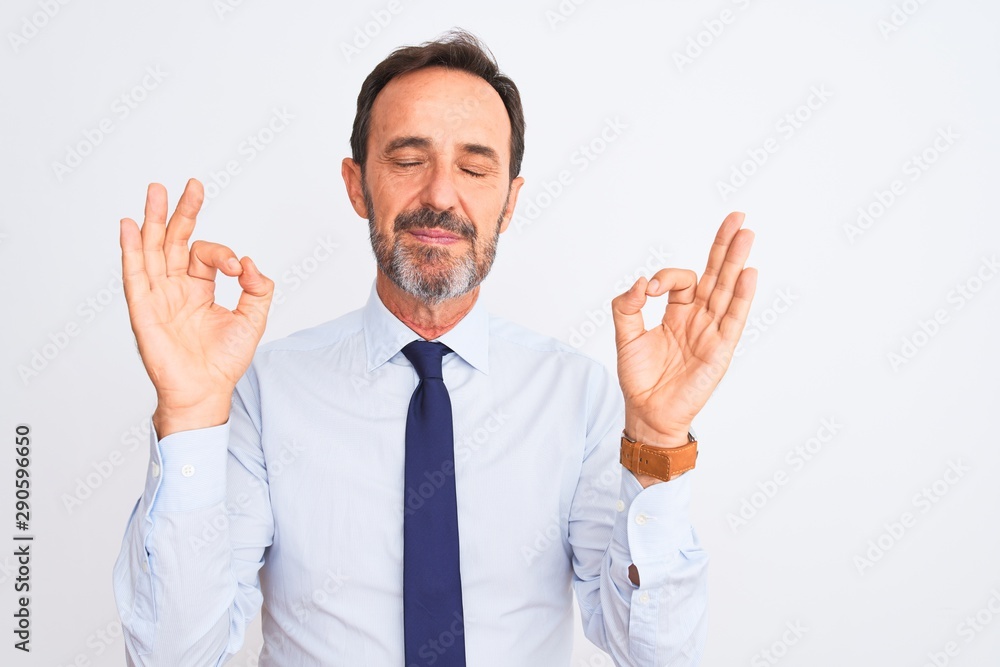 Middle age businessman wearing elegant tie standing over isolated white background relax and smiling with eyes closed doing meditation gesture with fingers. Yoga concept. Middle age businessman wearing elegant tie standing over isolated white background relax and smiling with eyes closed doing meditation gesture with fingers. Yoga concept.