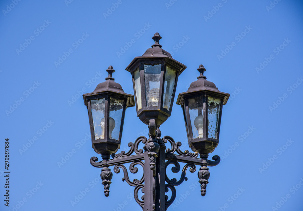 Old street triple lamp. Old lamp with modern bulbs. Old street triple lamp. Old lamp with modern bulbs.
