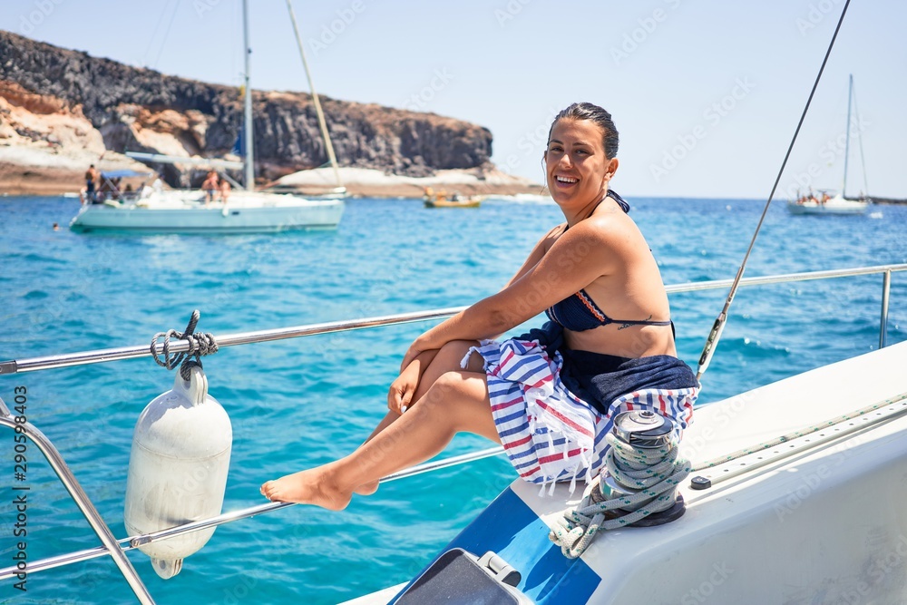 Young beautiful woman smiling happy, sailing on a boat on a sunny day on holidays Young beautiful woman smiling happy, sailing on a boat on a sunny day on holidays