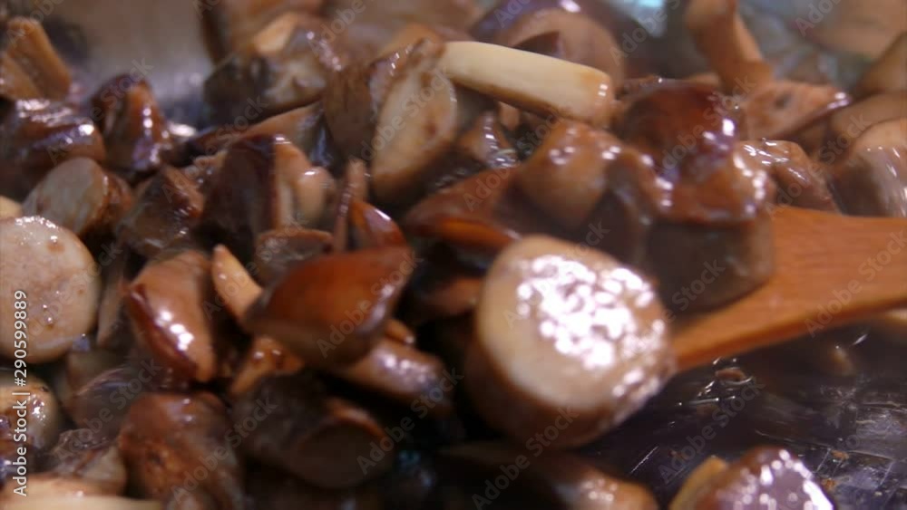 Delicious mushrooms are stewed in a pan and turned over with a spatula Delicious mushrooms are stewed in a pan and turned over with a spatula