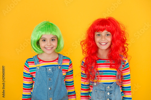 Sisters having fun. Pigment dye hair. Freedom for expression. Fantasy hair trend. Semi permanent color cream. Colored clip in hair extensions. Change color. Kids girls with vibrant hairstyle