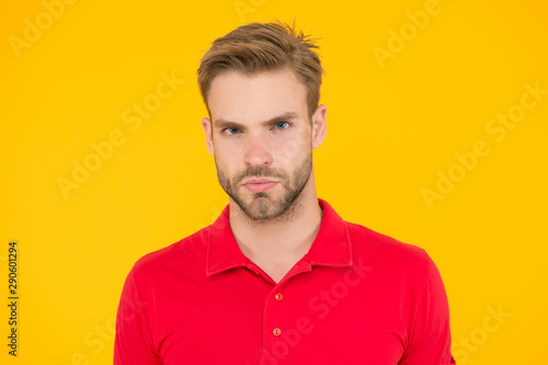 Strict glance. Handsome man unshaven face and stylish hair. Caucasian man on yellow background. Bearded man in casual style. Handsome guy portrait. Facial hair and skin care concept. Handsome face