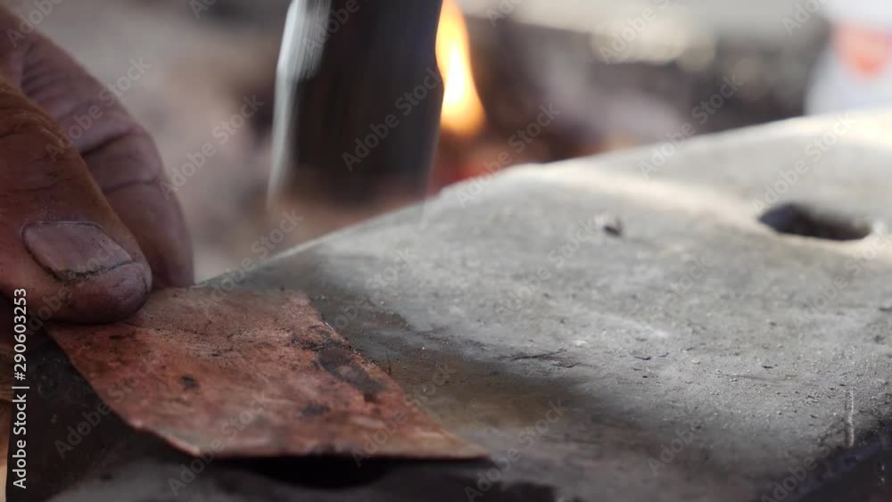 Flattening and forming a bronze pipe on an anvil to prepare it for making into a handmade knife. Flattening and forming a bronze pipe on an anvil to prepare it for making into a handmade knife.