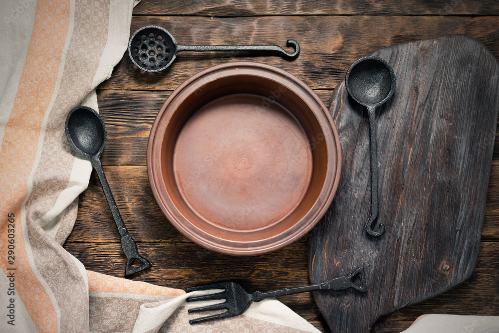 Empty plate with a copy space for food and spoon and fork on a brown wooden kicthen table background. Empty plate with a copy space for food and spoon and fork on a brown wooden kicthen table background.