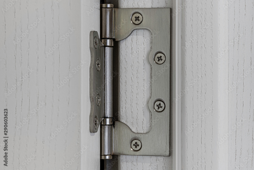 Closeup view of a hinge in white wooden doors. Closeup view of a hinge in white wooden doors.