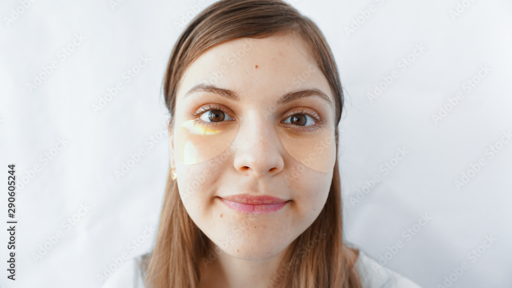Beauty Face Skin Care. Closeup Of Young Woman With Beautiful Big Eyes, Natural Makeup And Fresh Facial Skin Applying Under-eye Patches On Face