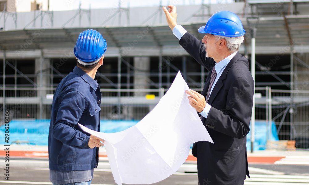 Two architect developers reviewing building plans at construction site Two architect developers reviewing building plans at construction site