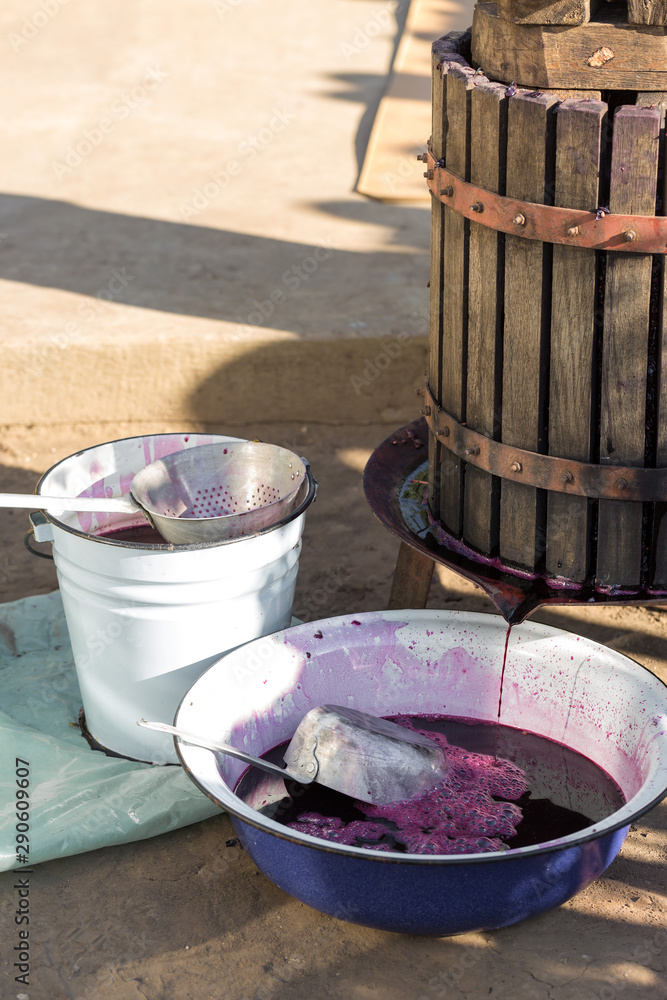 Winepress with red must and helical screw. Traditional old technique of