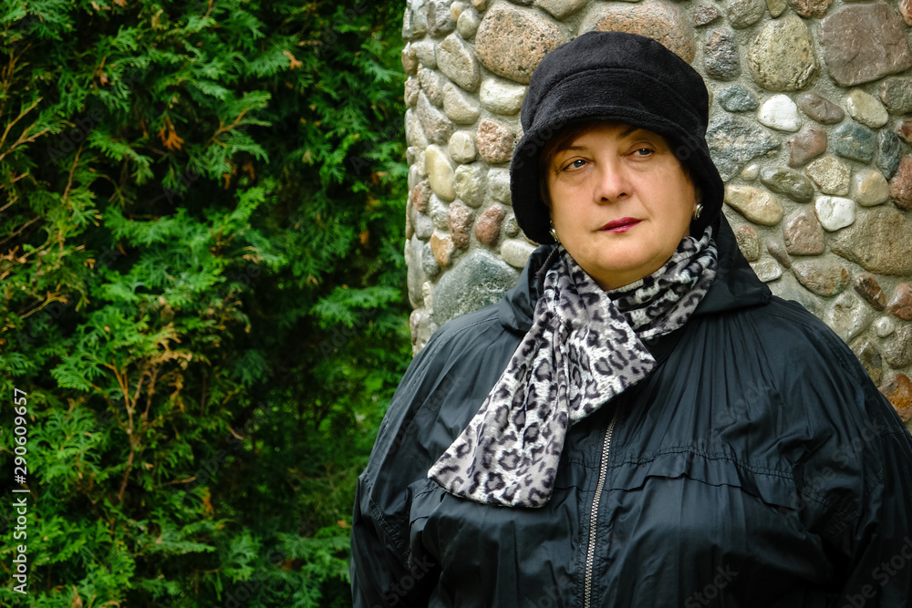 Pensive Mature woman in a black hat resting Pensive Mature woman in a black hat resting