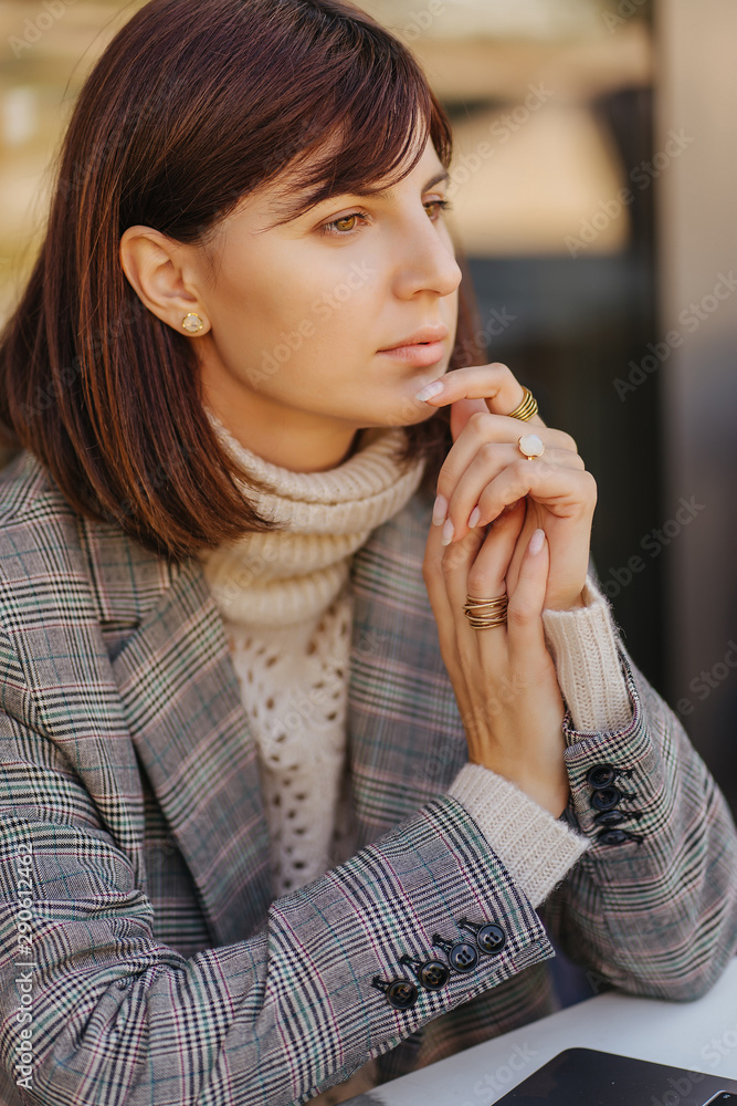Portrait Young woman in warm sweater and blazer in a cafe on the terrace Portrait Young woman in warm sweater and blazer in a cafe on the terrace