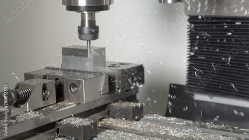 Fotografia CLOSE UP: Shiny shavings fly off a piece of aluminium being processed by a drill
