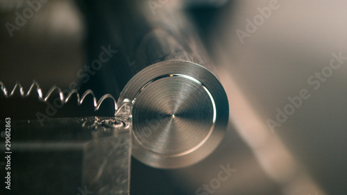 MACRO, DOF: Lathe tool cutting a small groove into the middle of a metal rod. photo