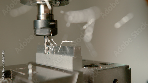 Fotografie MACRO: Sharp industrial drill spinning and end milling a piece of aluminium