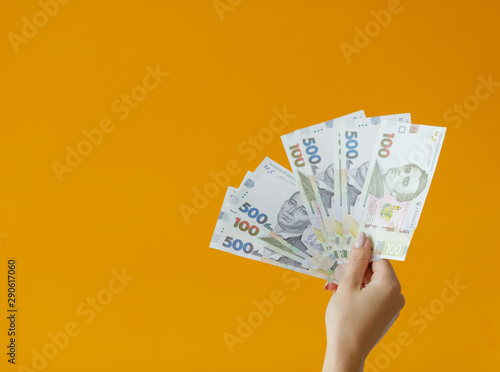 Close-up Hands holding lots of money. One hundred dollars banknotes and Ukrainian hryvnia. Background of business concept top view with copy space