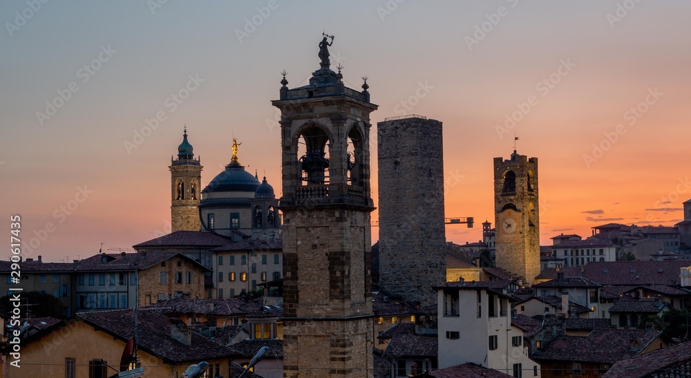 Bergamo at sunset in the old city with towers and bell tower,