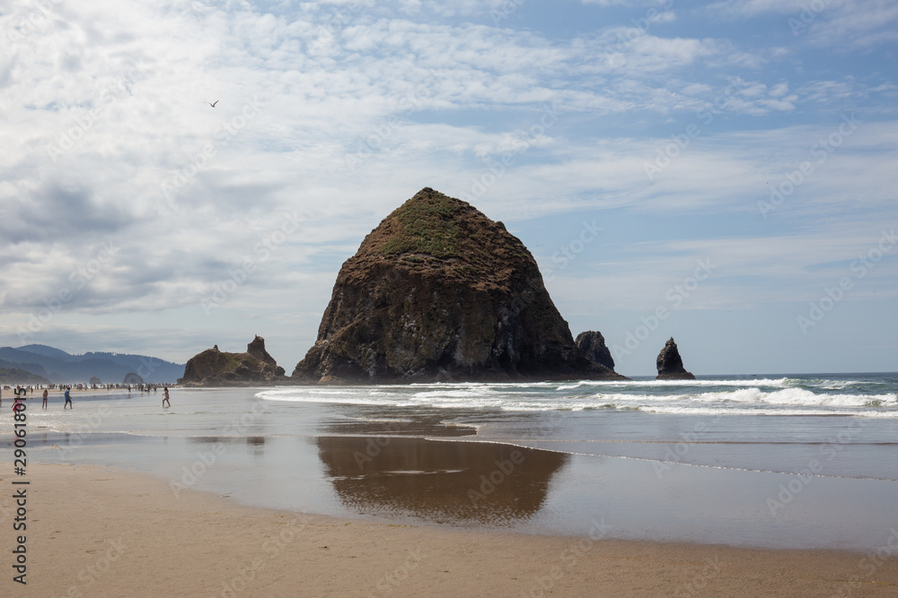 Cannon Beach, Oregon coast: the famous Haystack Rock reflects itself in the water