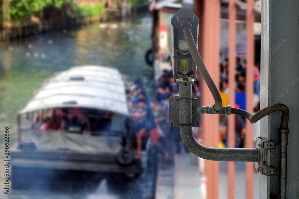 Rear view of CCTV cameras that installed on overpass for assist to monitor safety of blurred group people who are using passenger boats for travel in Bangkok, Thailand Rear view of CCTV cameras that installed on overpass for assist to monitor safety of blurred group people who are using passenger boats for travel in Bangkok, Thailand