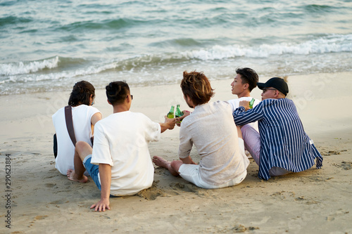 Photography group of asian men drinking beer on beach