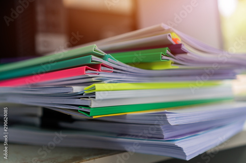 Piles unfinished documents reports files with overwork paper corner on teacher school desk office at university of Thailand. Stack of messy paperworks assessment legal folder at workplace concept