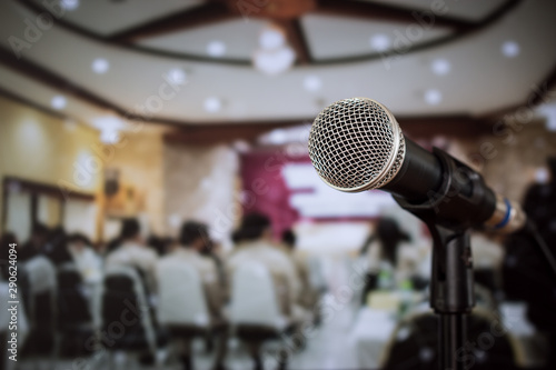 Seminar Conference Concept : Close-up Microphones on abstract blurred of speech in meeting room, front speaking blur people in event convention hall with lens light flare in hotel background