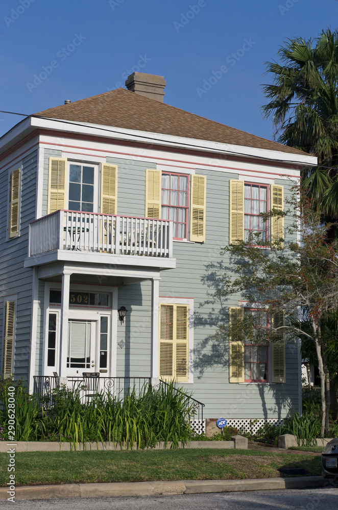 Vertical: Simple, historic,  square, wooden frame, two story house in Galveston, Texas