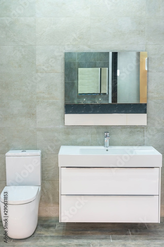 Modern spacious bathroom with bright tiles with toilet and sink. Side view