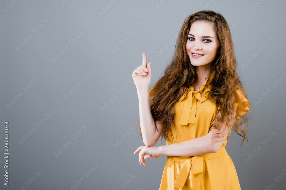 happy smiling beautiful girl pointing up at copyspace happy smiling beautiful girl pointing up at copyspace