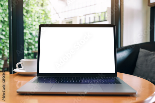 Mockup image of laptop computer with blank white desktop screen on wooden table